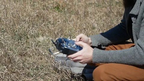 Man Piloting Tiny Radio Controlled Helicopter With Radio Remote Control outdoor. Stock Footage 128988812