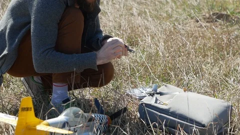Man Piloting Tiny Radio Controlled Helicopter With Radio Remote Control outdoor. Stock Footage 128988819