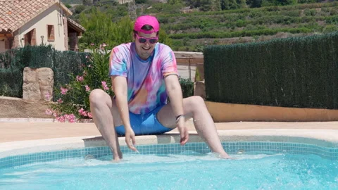 A man in a pink hat sits in a pool Stock Footage 278000670