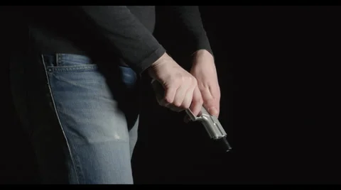 Man with a pistol comes in the frame, reload a pistol Stock Footage 62587958