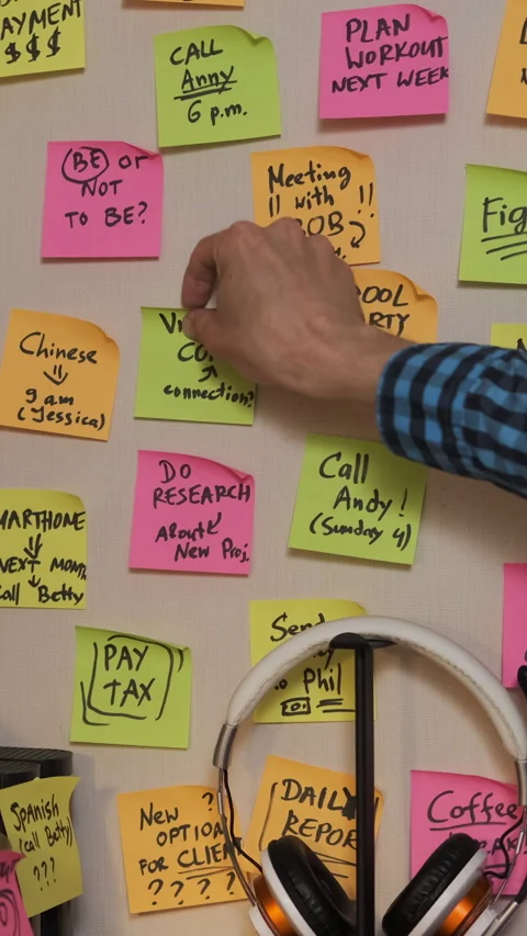 Man places notes on wall over his desk Video stock 282913007