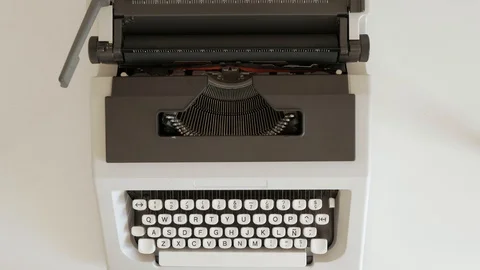 A man places a sheet of paper on a typewriter, Stock Footage 124863894