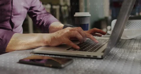 Man placing arms and typing on laptop, phone; binary overlay over arms showing Stock Footage 331336098