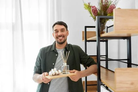 Man placing aroma reed diffuser to shelf home Stock Photos