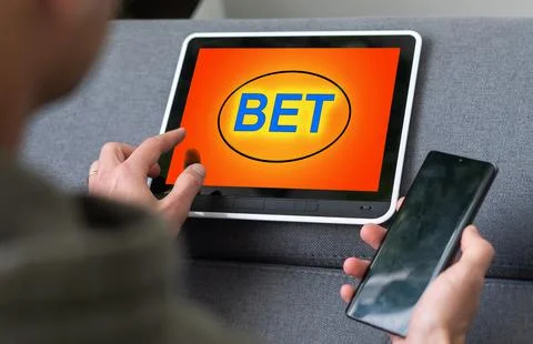 Man placing bet with tablet computer, closeup Stock Photos
