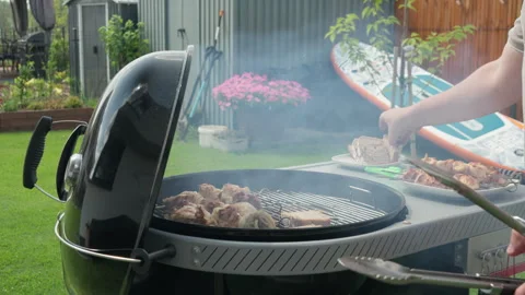 Man placing bread slices on a hot charcoal grill during a barbecue cookout Stock Footage 340163203