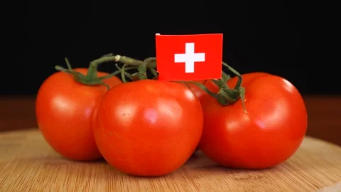 Man placing decorative toothpick with flag of Switzerland into bunch of tomatoes Stock Footage 152787997