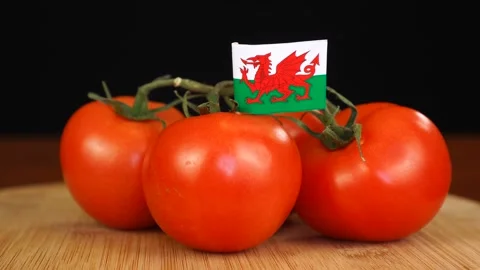 Man placing decorative toothpick with flag of Wales into bunch of tomatoes. Stock Footage 152789242