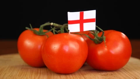 Man placing decorative toothpick with flag of England into bunch of tomatoes. Stock Footage 152790333