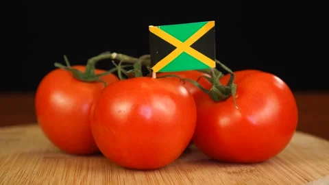 Man placing decorative toothpick with flag of Jamaica into bunch of tomatoes. Stock Footage 152791249