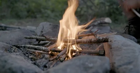 Man placing firewood on the campfire Stock Footage 145280340
