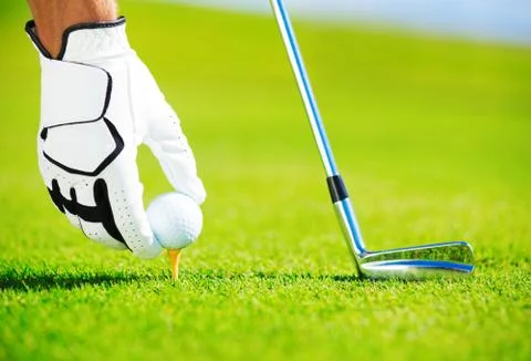 Man placing golf ball on tee Stock-Fotos
