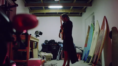 Man placing a guitar strap over his shoulder Stock Footage 279787229