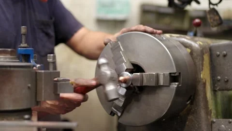 Man placing a piece of a machine using a hammer Stock Footage 258980381