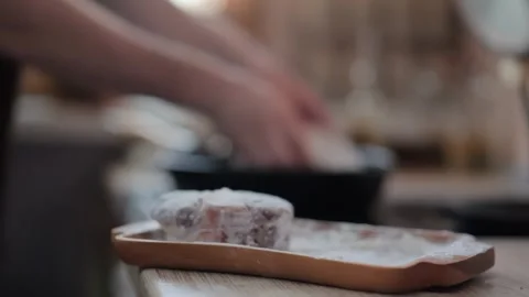 Man placing a raw Osso Buco steak onto a hot skillet Stock Footage 316087008