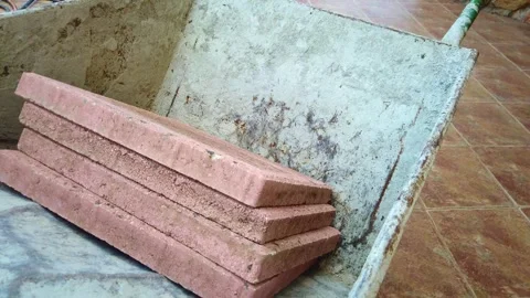 Man placing a red pathing stone into a wheel barrow, then proceeds to move onto Vidéo 333888895