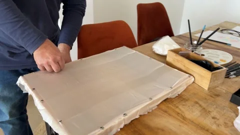 Man placing silk fabric on the frame in silk painting workshop Stock Footage 330611750