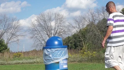 Man placing trash in a public garbage can Stock-Footage 95941164