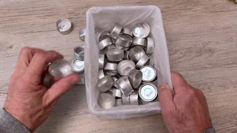 A man placing used tealight holders into a container. Stock Footage 321481486