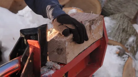 Man in plaid jacket splits wood using a hydraulic wood splitter 5 Stock Footage 1008923