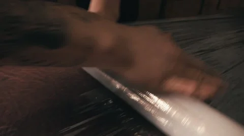 Man in a plaid shirt pulls stretch film over tattoo table. Close up pan shot Video stock 67567992
