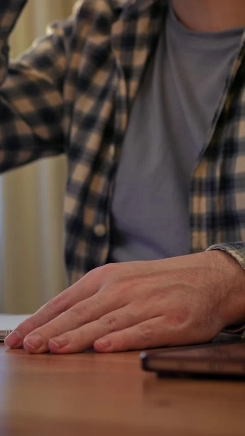 Man in plaid shirt taking notes casually. Individual in casual attire writes Video stock 344739269