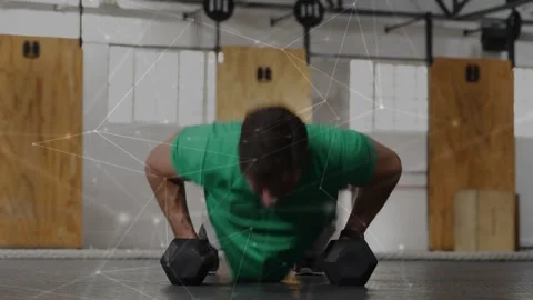 Man from plank, doing pushups, switching dumbbell rows on gym floor, building Stock Footage 330980638