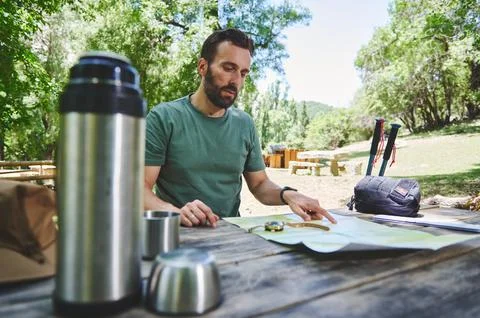 Man Planning a Hike Using a Map at an Outdoor Picnic Table Stock Photos
