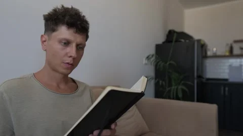 Man planning monthly budget at home, using smartphone to calculate expenses and 스톡 동영상 346251553