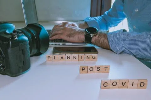 Man plans photographic trip using laptop in post covid period Stock Photos