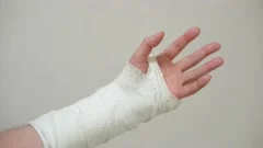 Male Hand, Wrapped In A Plaster Cast, Scrolls Through A Touchscreen On A  Mobile Phone. Unrecognizable Man In Black T-shirt With Broken Wrist Surfs  The Internet At Home Stock Photo, Picture and