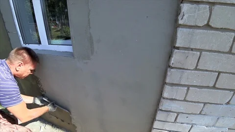 The man plastered the wall. Contractor plasterer working outdoors. Stock Footage 95422100