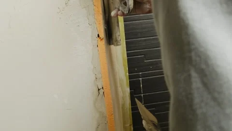 Man plasterer seals insulation boards applying putty with trowel Stock Footage 304416415