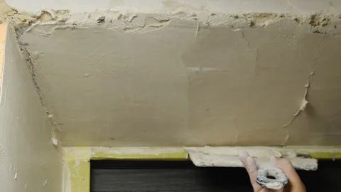 Man plasterer smooths out layer of putty on plastered wall 스톡 동영상 304423013