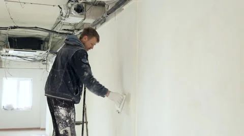 Man plasterers wall aligns sandpaper Stock Footage 46508905