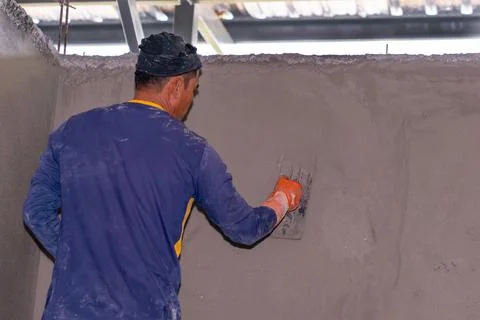 The man plastering cement at wall. Stock Photos