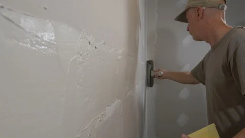 A man plastering drywall on a construction project Stock-Footage 96086824