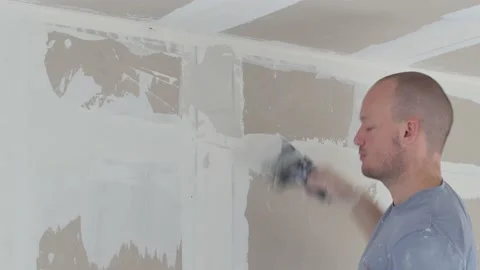 Man plastering wall with putty-knife, close up image. Fixing wall surface and Video stock 147514803