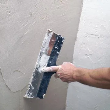 A man plastering a wall with a spatula Foto stock