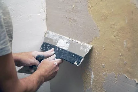 A man plastering a wall with a spatula 스톡 사진