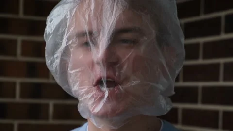A man, with a plastic bag on his head, suffocates due to lack of oxygen 库存影片 231574530