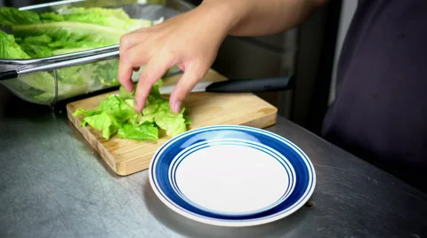 Man Plating Chopped Lettuce on Plate - 4K Resolution Stock Footage 59786205