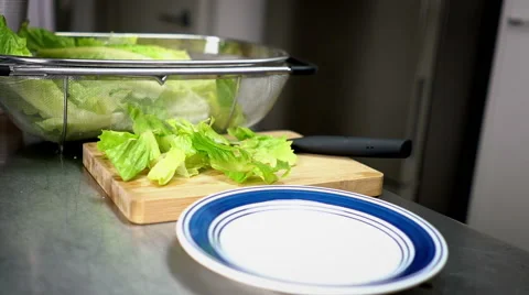 Man Plating Chopped Lettuce on Plate 60 fps Stock Footage 59786273