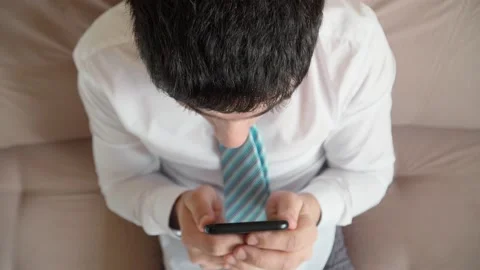 Man is played in smartphone and win. Guy uses mobile phone and rejoices victory Stock Footage 148524956
