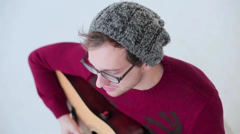 Man playing an acoustic guitar on the white studio background Stock Footage 62531918