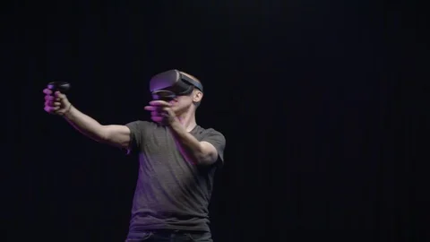 Man playing an Action Game in Virtual Reality on Black Background Stock-Footage 118903872
