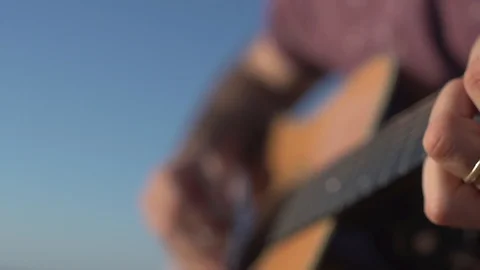 Man Playing and tuning acoustic Guitar Close Up shot side angle shot outdoor Video stock 100201671