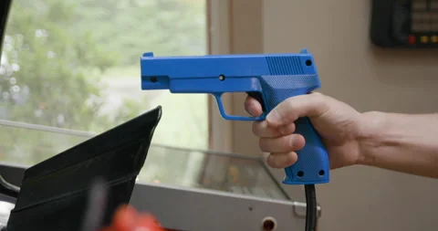 Man Playing Arcade Shooting Game with Blue Light Gun 動画素材 137429678