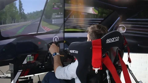 Man playing auto simulator video arcade game Stock Footage 76873521