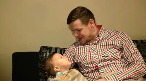 Man playing with baby on sofa  Stock Footage 60898456